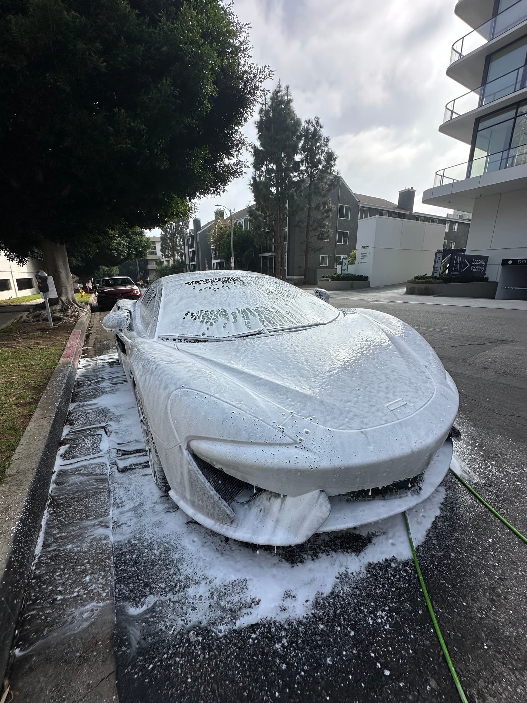 McLaren covered in thick foam during the pre-wash decontamination stage