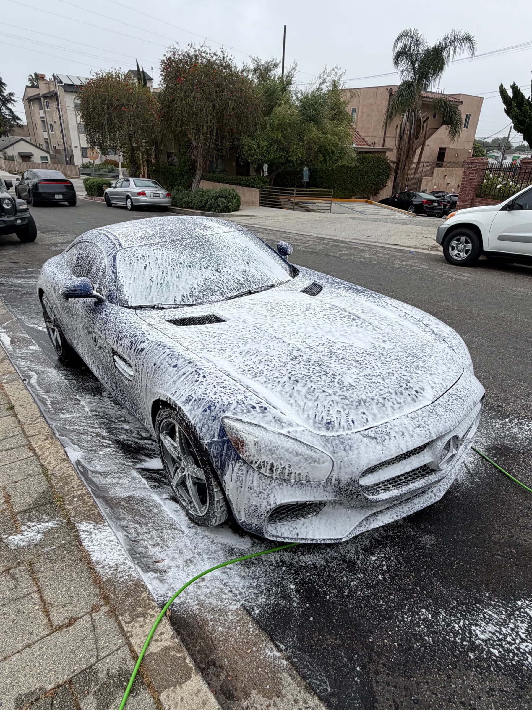 Mercedes-AMG GT covered in foam during the pre-wash decontamination stage