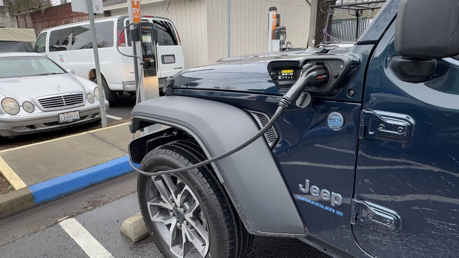 Detailing a Tesla or EV — electric vehicle charging Dark blue Jeep Wrangler 4xe plug-in hybrid charging at a public EV charger
